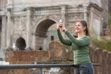 Foro Romano, Rom, İtalya, selfie çekim onun smartphone ile antika Romen binası önünde yeşil kazak giyen genç kadın