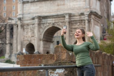 Foro Romano, Rom, İtalya, selfie çekim onun smartphone ile antika Romen binası önünde yeşil kazak giyen genç kadın