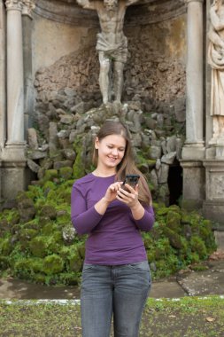 Villa Aldobrandini, Frascati, İtalya, Genç kadında önünde antika fontain, manifatura ile smartphone