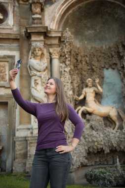 Villa Aldobrandini, Frascati, İtalya, Genç kadında önünde antika fontain, smartphone ile işaretlenmiş selfie (fotoğraf)