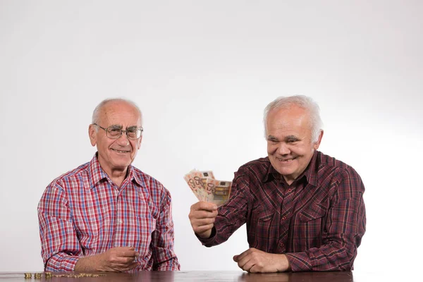two elderly men with euro money