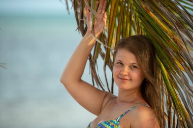 Palmiye ağacı üzerinde bikini genç kız