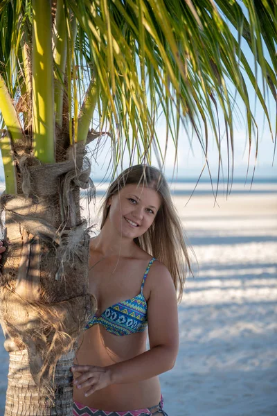 Young girl in bikini behind the palm tree — Stock Photo, Image