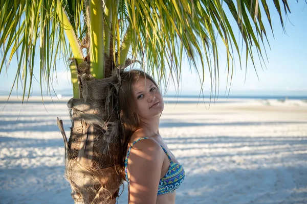 Jong meisje in bikini naast de palmboom — Stockfoto