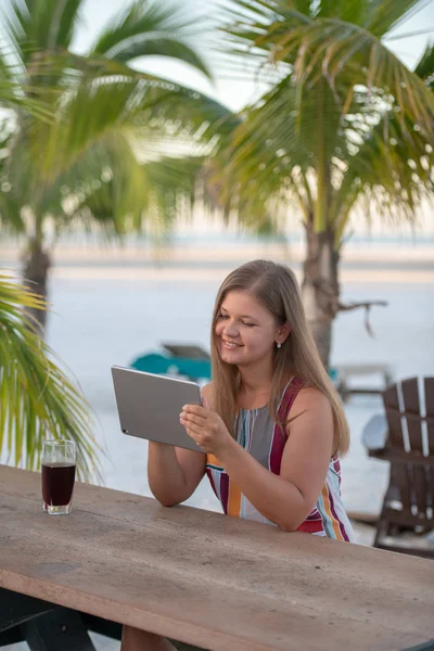 Giovane donna con tablet sulla spiaggia — Foto Stock