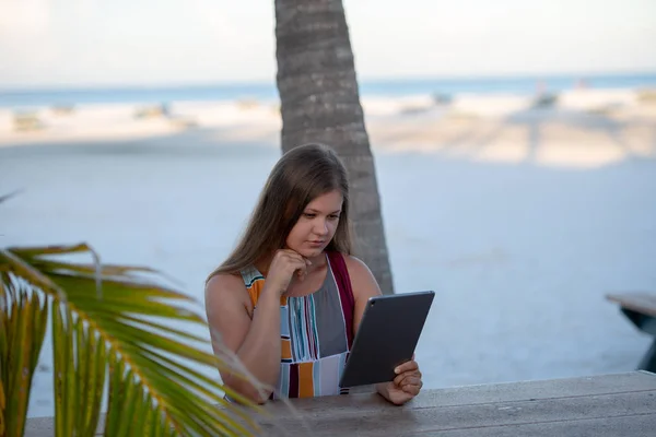 Jeune femme avec tablette sur la plage — Photo
