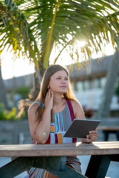 Młoda kobieta z tabletek na plaży — Zdjęcie stockowe