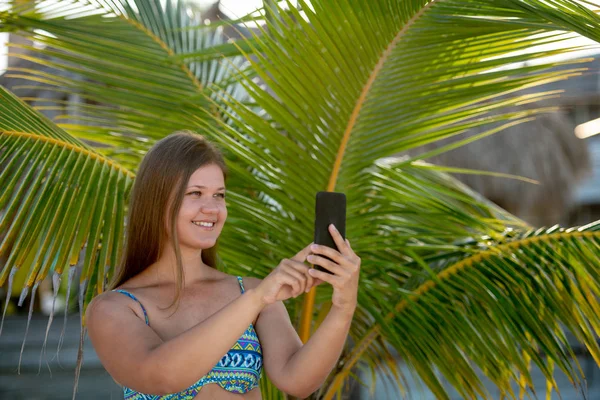 Glückliche junge Frau macht Selfie am Strand — Stockfoto