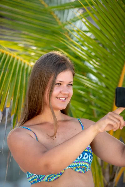 Junge Frau mit Smartphone vor der Handfläche — Stockfoto