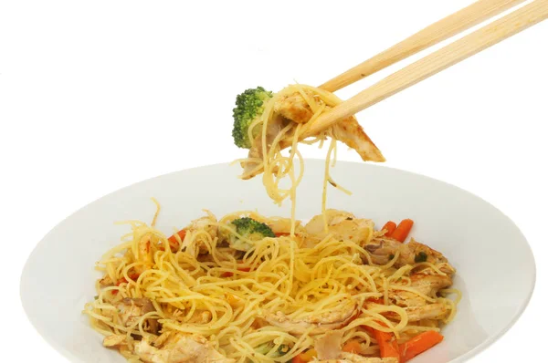 白い背景に ボウルの上の箸で鶏と野菜と麺の炒めのクローズ アップ — ストック写真