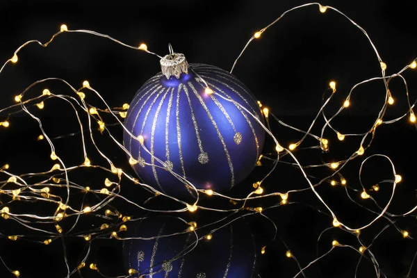 Blauwe Zilveren Kerstbal Omringd Door Fairy Verlichting Tegen Een Zwarte — Stockfoto