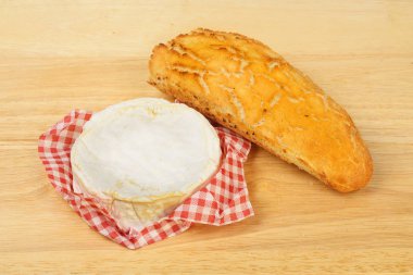 Bütün camembert peyniri ve bir ekmek bir Ahşap Doğrama tahtası üzerinde rulo
