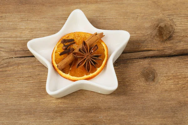 在古老的乡村木材上 在星形的盘子里 用橘子 八角和丁香干 — 图库照片