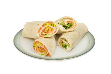 Tütsülenmiş somon, marul ve krem peyniri beyaza karşı izole edilmiş bir tabakta.