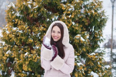 Aşağı kapüşonlu ceket ve kar eldivenleri genç güzel duygusal kadın portresi Bahçe arka plan kapsamında. Karlı kış manzarası