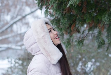 Aşağı kapüşonlu ceket ve kar eldivenleri genç güzel duygusal kadın portresi Bahçe arka plan kapsamında. Karlı kış manzarası