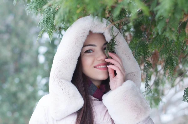 ダウン フード付きコートと手袋を雪の上で若い美しい感情的な女性の肖像画には 庭の背景が覆われています 雪に覆われた冬の風景 — ストック写真