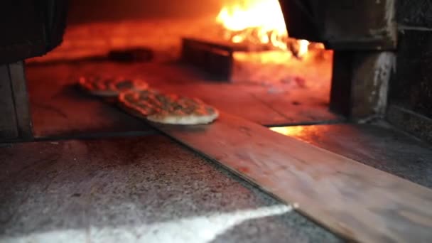 Traditional Turkish Pita or pide bread with sesame on wooden oar in brick oven or stone stove oven. — Stock Video