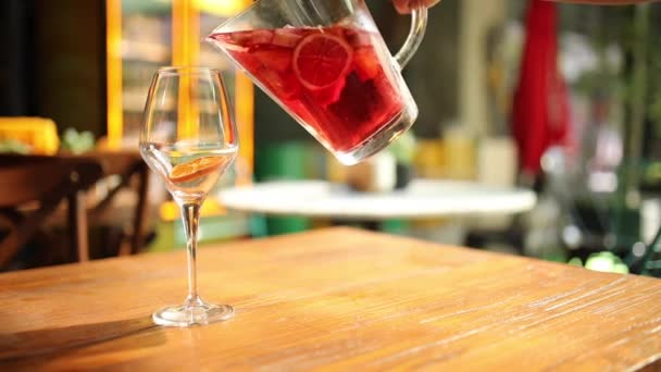 Kvinna hand hälla Rosen vin sangria cocktail från tillbringare till glas. — Stockvideo