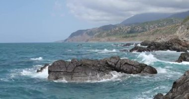 Dalgalar okyanusveya denizde kayalara çarpıyor ve çarpıyor. Güzel doğal doğa manzara. 