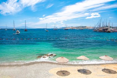 Bodrum Plajı, Ege Denizi, geleneksel beyaz evler, çiçekler, marina, yelkenli tekneler, Bodrum şehrinde veya Türkiye'de yatlar manzarası. 