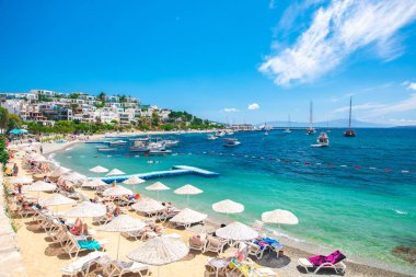 Bodrum Plajı, Ege Denizi, geleneksel beyaz evler, çiçekler, marina, yelkenli tekneler, Bodrum şehrinde veya Türkiye'de yatlar manzarası. 