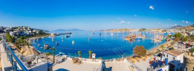 Türkiye'nin Bodrum şehrinde Ege Denizi'nin Panoramik Manzarası, geleneksel beyaz evler, marina, yelkenli tekneler ve yatlar. Ege tarzı turkuaz su.