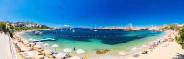 Bodrum Plajı, Ege Denizi, geleneksel beyaz evler, çiçekler, marina, yelkenli tekneler, Bodrum şehrinde veya Türkiye'de yatlar manzarası. 