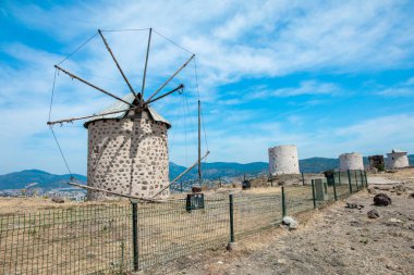 Türkiye'nin Bodrum şehrinde eski beyaz yel değirmenleri görünümü. Santorini Yunanistan'da Ege tarzı geleneksel beyaz rüzgar değirmenleri
