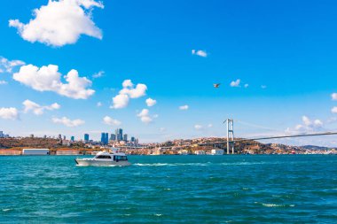Güneşli bir günde Marmara Denizi'nde Boğaz Köprüsü ile İstanbul'un Panoramik Manzarası ve Bulutlar