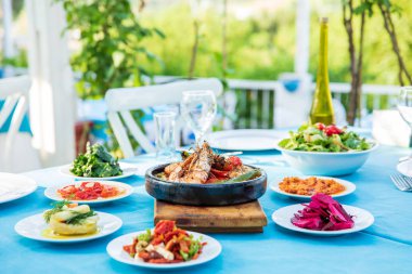 Karides, Deniz Ürünleri, mezeler ve salatalar Fish Restaurant'ta masada. Yunanistan veya Türkiye'de Beach Restaurant. Bodrum, Santorini veya Mikonos'ta Ege sahili, Yunan veya Türk tarzı balık restoranı