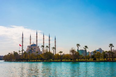 Seyhan Nehri ve Ağaçlar ile Adana'da Sabancı Merkez Camii. Cami, mavi temiz gökyüzü ile güneşli bir günde Seyhan nehriyansımaları vardır