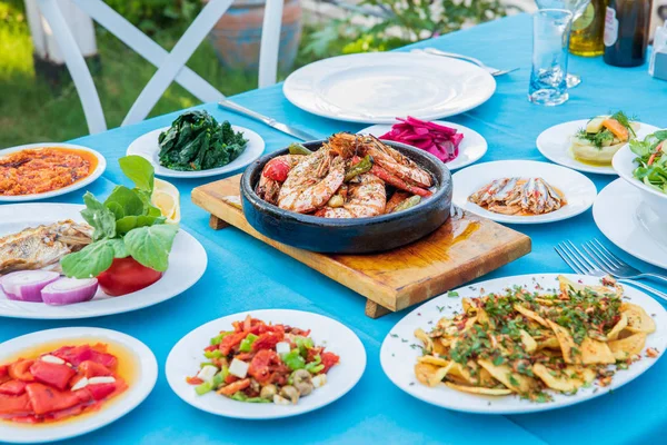 鱼餐厅的餐桌上摆着虾 开胃菜和沙拉 位于希腊或土耳其的海滩餐厅 爱琴海海滨 希腊或土耳其风格的鱼餐厅在博德鲁姆 圣托里尼或米科诺斯 — 图库照片