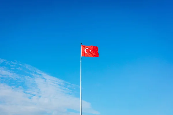 土耳其国旗在乌云和阳光的蓝天上飘扬 — 图库照片