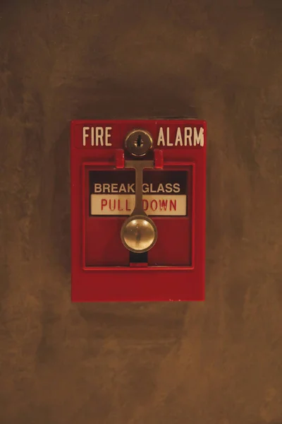 Fire alarm switch box on the wall. Emergency fire extinguisher sign alarm at hotel, hospital or office wall
