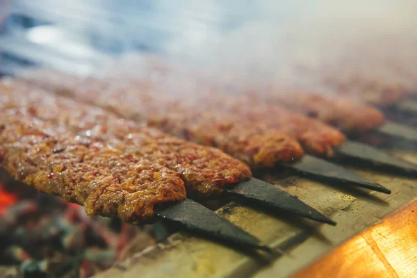 传统的土耳其阿达纳烤肉串或Kebap在餐厅的烤架上与烤肉串晚餐 — 图库照片