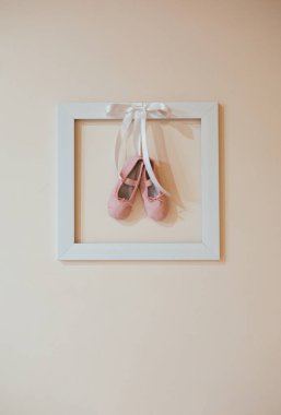Çerçeve içinde duvarda balerin ayakkabıları. Duvarda asılı bale dansçı sıyrık ayakkabıları.