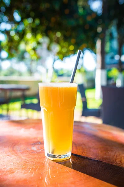 屋外の木製テーブルにオレンジジュースのグラス — ストック写真