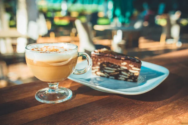 Açık havada ahşap masada latte kahve ve kek