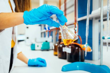 Koruyucu eldivenkadın veya kadın elleri elinde test tüpü tutun kimya deney testi ve modern kimya laboratuvarında araştırma üretir. 