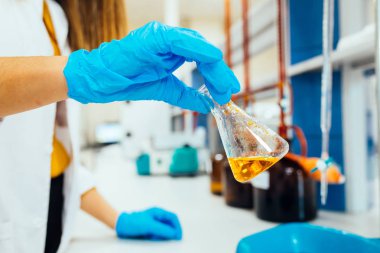 Koruyucu eldivenkadın veya kadın elleri elinde test tüpü tutun kimya deney testi ve modern kimya laboratuvarında araştırma üretir. 