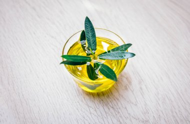 Organik, doğal ve sağlıklı soğuk preslenmiş zeytinyağı ahşap masaya. Sağlıklı vejetaryen veya vegan kahvaltı için bir kase içinde Virgin İtalyan veya İspanyol zeytinyağı konsept görüntü kadar yakın.