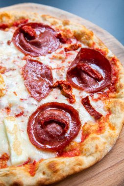 Lezzetli, taze ve lezzetli düz ekmek İtalyan pepperoni veya margherita pizza. Napoli'deki restoranda Salam, peynir ve fesleğenli pizza manzarası. Pizza arka plan doku deseni