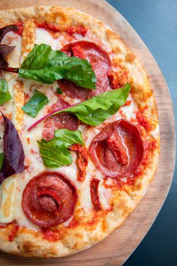 Lezzetli, taze ve lezzetli düz ekmek İtalyan pepperoni veya margherita pizza. Napoli'deki restoranda Salam, peynir ve fesleğenli pizza manzarası. Pizza arka plan doku deseni
