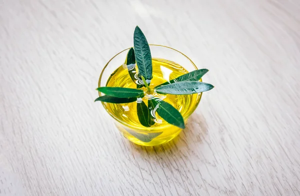 Organic, natural and healthy cold pressed olive oil on wooden table. Virgin italian or spanish olive oil in a bowl for healthy vegetarian or vegan breakfast close up concept image.