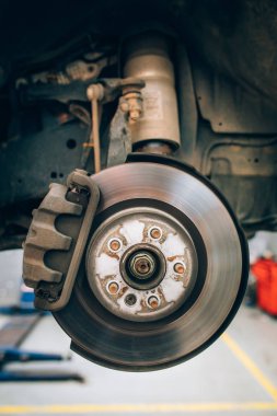 Tekerlek lastiği değişimi veya onarımı sırasında araç diskfreninin kapatılması. Oto servis garajında bakım sırasında aracın disk fren.