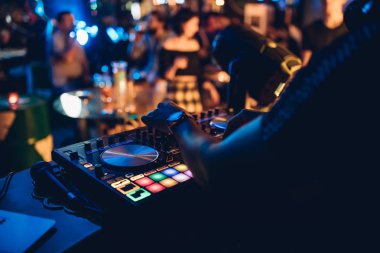 DJ, gece kulübünde canlı set ve pikabın konsolunda karışık müzik çalar. Disk Şakacı Eller kulüp partisinde ses karıştırıcı istasyonunda. Müzik çalmak ve parti yapmak için DJ karıştırıcı denetleyici paneli.