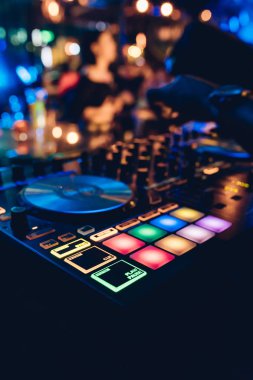 DJ, gece kulübünde canlı set ve pikabın konsolunda karışık müzik çalar. Disk Şakacı Eller kulüp partisinde ses karıştırıcı istasyonunda. Müzik çalmak ve parti yapmak için DJ karıştırıcı denetleyici paneli.
