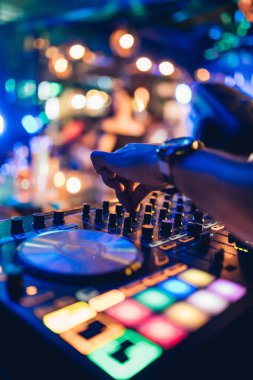 DJ, gece kulübünde canlı set ve pikabın konsolunda karışık müzik çalar. Disk Şakacı Eller kulüp partisinde ses karıştırıcı istasyonunda. Müzik çalmak ve parti yapmak için DJ karıştırıcı denetleyici paneli.