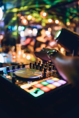 DJ, gece kulübünde canlı set ve pikabın konsolunda karışık müzik çalar. Disk Şakacı Eller kulüp partisinde ses karıştırıcı istasyonunda. Müzik çalmak ve parti yapmak için DJ karıştırıcı denetleyici paneli.